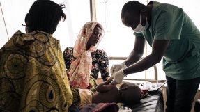 Ettåriga Mercian ligger på en brits på en vårdinrättning i Kongo-Kinshasa. Hon undersöks av en medarbetare från Läkare Utan Gränser för feber, diarré och hosta på 