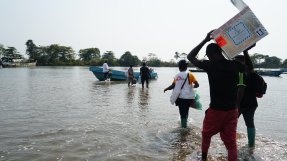 Ett team från Läkare Utan Gränser vadar ut till en båt efter att ha vaccinerat 419 personer mot kolera i byn Enyenge, sydvästra Kamerun.