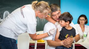 En pojke från Afghanistan får vaccin mot mässling i ett flyktingläger i Grekland