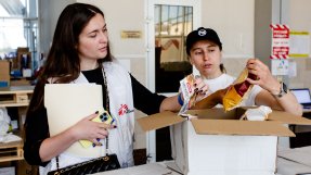 Daria Samoilova (v) och Yana Biletskaya (h) går igenom en av lådorna med mat från Läkare Utan Gränser.