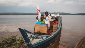 Två personer från Läkare Utan Gränser lastar av materiel från en båt