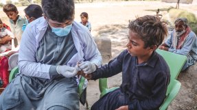 Ett Läkare Utan Gränser tekniker tar ett blodprov i fingret på ett barn.