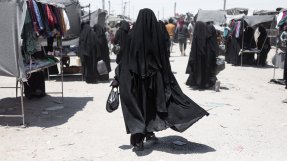 En kvinna iklädd burka går på en marknads i al-Hol.