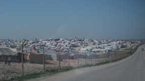 Bakom staketet syns al-Hol lägret, där över 55 000 personer är inlåsta.