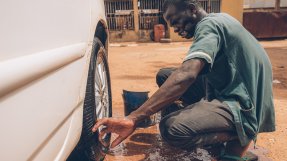 En man tvättar ett bildäck