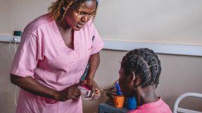 Barnmorska ger medicin till patient.