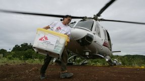 en kvinnlig anställd på Läkare Utan Gränser lastar av lådor ur en helikopter