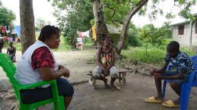 Kvinnlig personal pratar med två patienter.