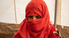 Närbild när en kvinna med röd hijab som tittar neråt.