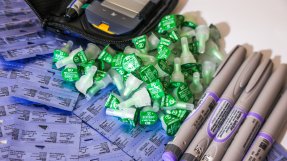 Insulinpennor, nålkapslar och en glukometer ligger på ett bord