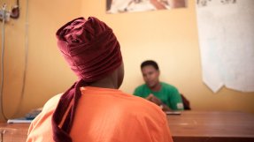 bild tagen bakifrån på en kvinna som sitter framför ett skrivbord