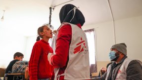 En kvinna i Läkare Utan Gränser väst ger en flicka ett oralt vaccin