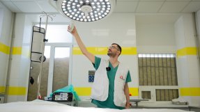 Läkare justerar ljuset över en sjukhussäng.