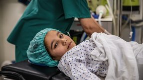 En flicka i sjukhuskläder ligger på en operationsbädd