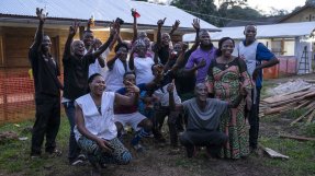 En grupp människor håller upp armarna och ser glada ut