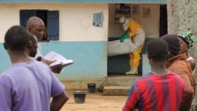 En av våra medarbetare tar hand om en avliden flicka som har dött i sitt hem i Foyaregionen i Liberia. Kroppen desinficeras och läggs i en body bag innan den kan begravas. FOTO: Martin Zinggl.
