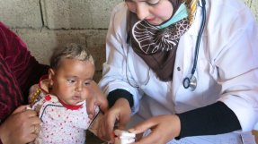En medarbetare tar hand om ett barn på vår mobila klinik i Taz Kharmatu i Irak. Foto: Gabriella Bianchi / MSF.