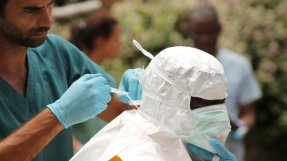 En av Läkare Utan Gränsers anställda i Liberia får hjälp att sätta på sig skyddsdräkt. FOTO: Martin Zinggl