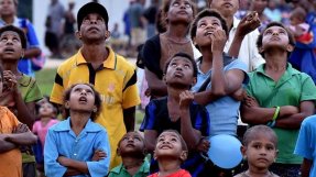 En grupp människor i Kerema, Papua Nya Guinea, tittar upp i luften efter en drönare. FOTO: Aris Messinis