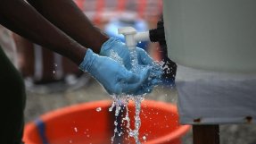 En hjälparbetare tvättar sina händer med klorerat vatten. FOTO: John Moore / Getty Images