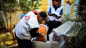 En läkare från Läkare Utan Gränser undersöker en migrant på kustbevakningens område på ön Symi i Grekland. FOTO: MSF