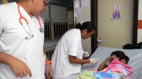 Personal på sjukhuset i San Pedro Sula tar hand om en liten patient med denguefeber. 