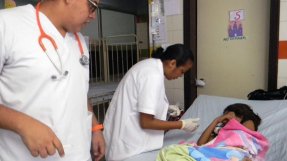 Personal på sjukhuset i San Pedro Sula tar hand om en liten patient med denguefeber.