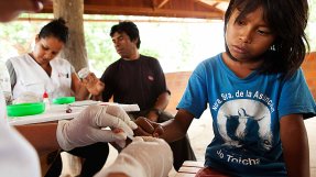 foto av en sjuksköterska som tar blodprov på ett barns finger