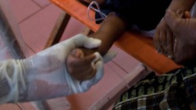 En sjuksköterska försöker sätta en infart på ett barn i Sierra Leone. 