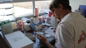 foto av man som granskar ett bakterieprov på ett sjukhus i Afghanistan