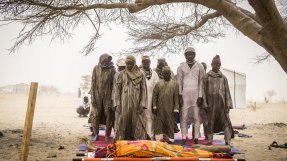 I ett flyktinglägret i Tchad sörjer nigerianska män en 38-årig kvinna som dött efter förlossning.