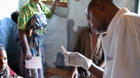 En sjuksköterska granskar ett malariatest på en vårdcentral i Remeka, Kongo-Kinshasa. 