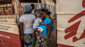 En mamma och hennes barn vid ingången till Castor sjukhus, Centralafrikanska republiken.