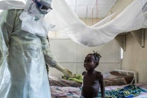 En sjuksköterska tar hand om ett barn som smittats med Lassafeber i Sierra Leone.