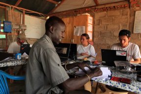 En grupp anställda sitter framför bärbara datorer på ett kontor.