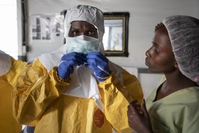 Sjukvårdspersonal tar på sig en skyddsdräkt för behandling av ebola i Bunia i Kongo-Kinshasa