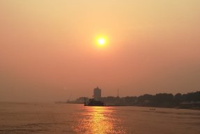 En sol ovanför vatten och land