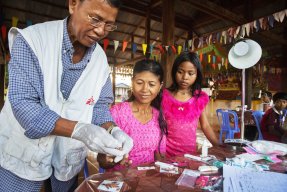 En läkare testar två patienter för malaria