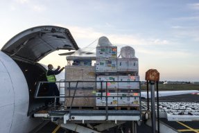 Pallar med medicinsk utrustning plockas in på ett plan