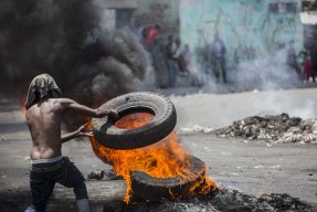 En demonstrant bränner däck i Port-au-Prince