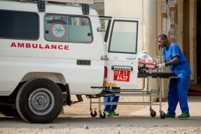 En patient på en bår lyfts in i en ambulans.