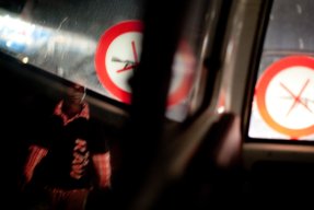 En man passerar en bilruta en sen kväll.