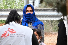 En kvinna får hjälp av en medarbetare från Läkare Utan Gränser.