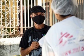 En man tittar på en personal från Läkare Utan Gränser och ler.