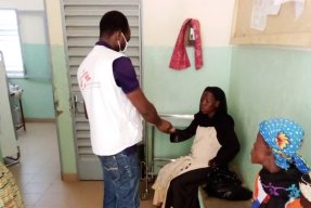 En anställd från Läkare Utan Gränser hälsar på en patient vid vårdcentralen i Fada, östra Burkina Faso.