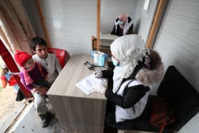 En sjuksköterska konsulterar med en ung pojke i nordvästra Syrien