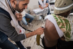 Personal från Läkare Utan Gränser undersöker en man på förvaret Dahr-el-Jebel i Libyen.