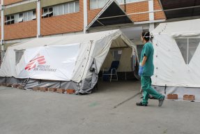 En personal från Läkare Utan Gränser passerar triagetältet för covid-19 utanför ett sjukhus i Caracas, Venezuela.
