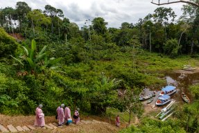 Personal påväg till båtar för transport i Amazonas regnskog