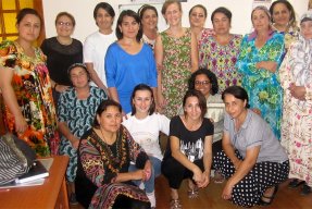 En stor grupp med kvinnliga medarbetar poserar framför kameran i sitt kontor